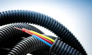 Trois fils électriques aux couleurs vives (rouge, jaune, bleu) sortent d'une gaine électrique noire ondulée.
