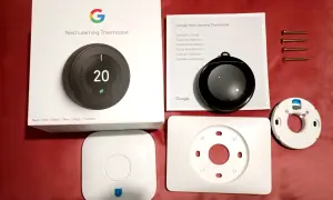 Kit pour l'installation d'un thermostat Nest Learning. Boîte, manuel, thermostat, socle et vis.