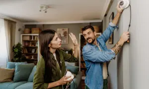 Un couple discute de la réglementation caméra de surveillance particulier pendant l'installation d'un appareil.
