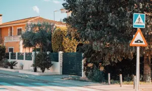 Panneau de passage piétons et ralentisseur. La question "un particulier peut-il filmer la voie publique" se pose devant cette maison.