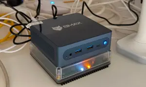Un mini-PC BMAX, prêt à assister Gladys, est allumé sur un socle transparent.
