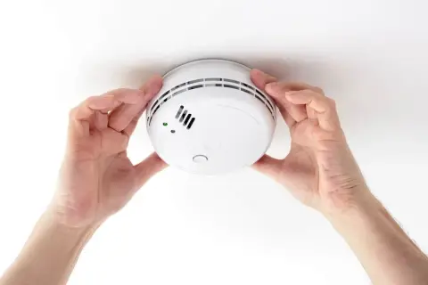Installation d'un détecteur de fumée. Ce geste garantit votre sécurité et constitue une attestation de détecteur de fumée valide.
