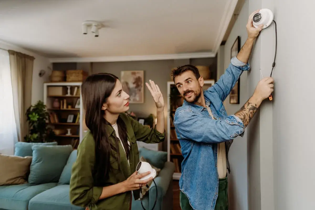 Un couple discute de la réglementation caméra de surveillance particulier pendant l'installation d'un appareil.