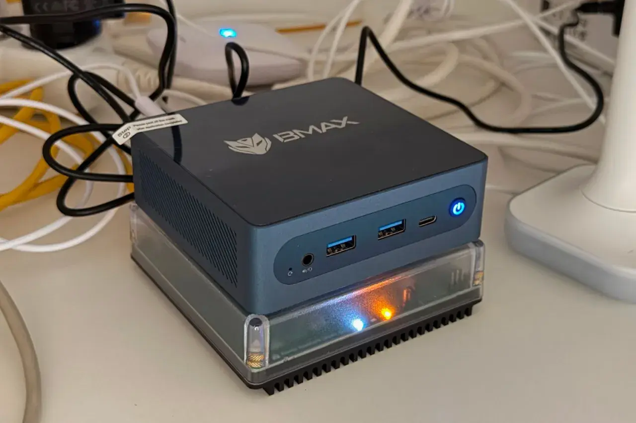 Un mini-PC BMAX, prêt à assister Gladys, est allumé sur un socle transparent.