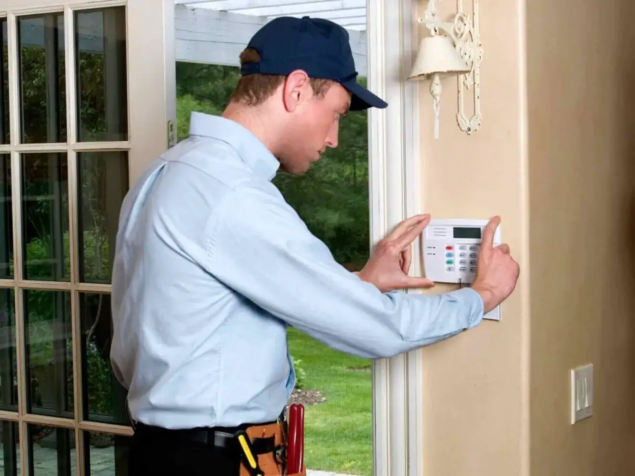 Un homme installe un panneau de contr&ocirc;le d'alarme &agrave; domicile. C'est une solution d'alarme &agrave; installer soi m&ecirc;me pour plus de s&eacute;curit&eacute;.